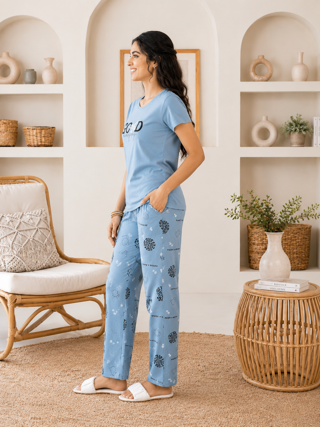 Woman wearing a blue pajama set in a cozy living room.