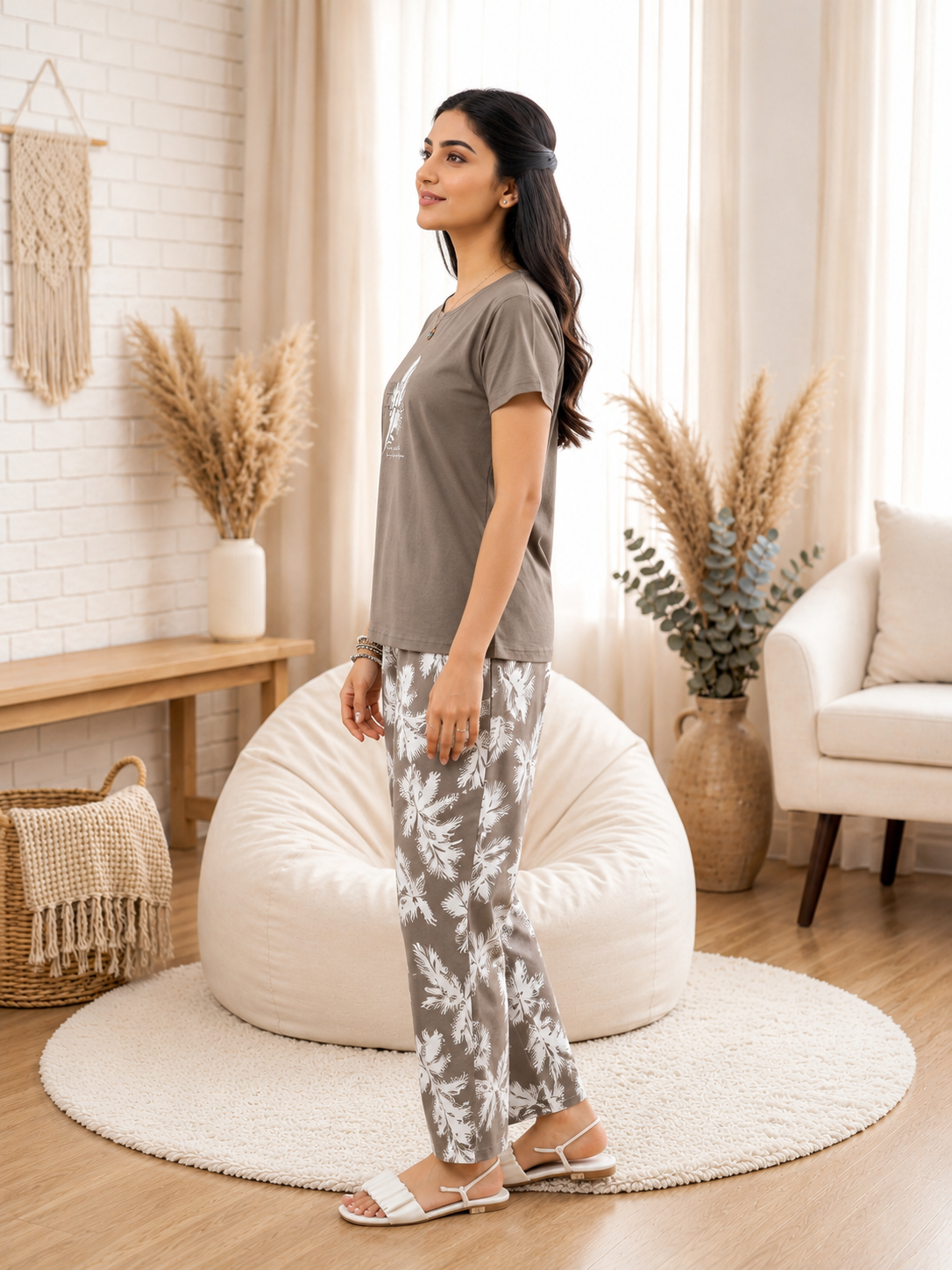 Woman standing in a cozy living room with a bean bag chair and decorative plants.