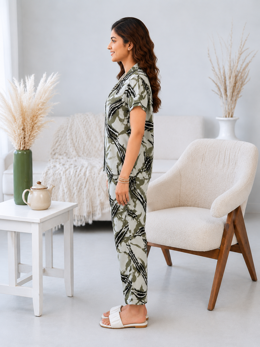 Woman in a patterned outfit standing in a modern living room.