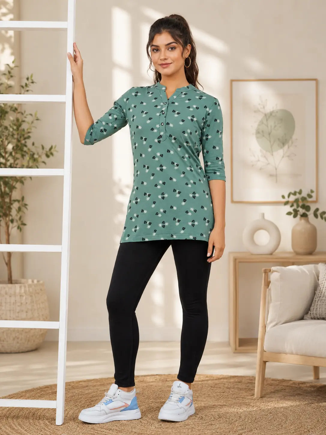 Woman wearing a green patterned top and black leggings in a home setting