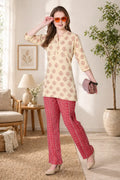 Woman wearing a patterned top and red pants in a living room setting